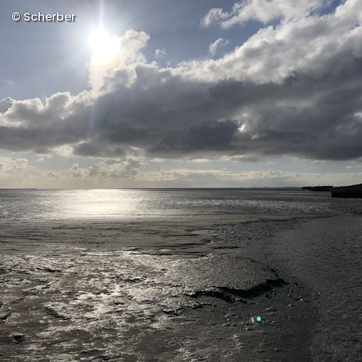Blick aufs Watt, Sonne blitzt hinter Wolke hervor