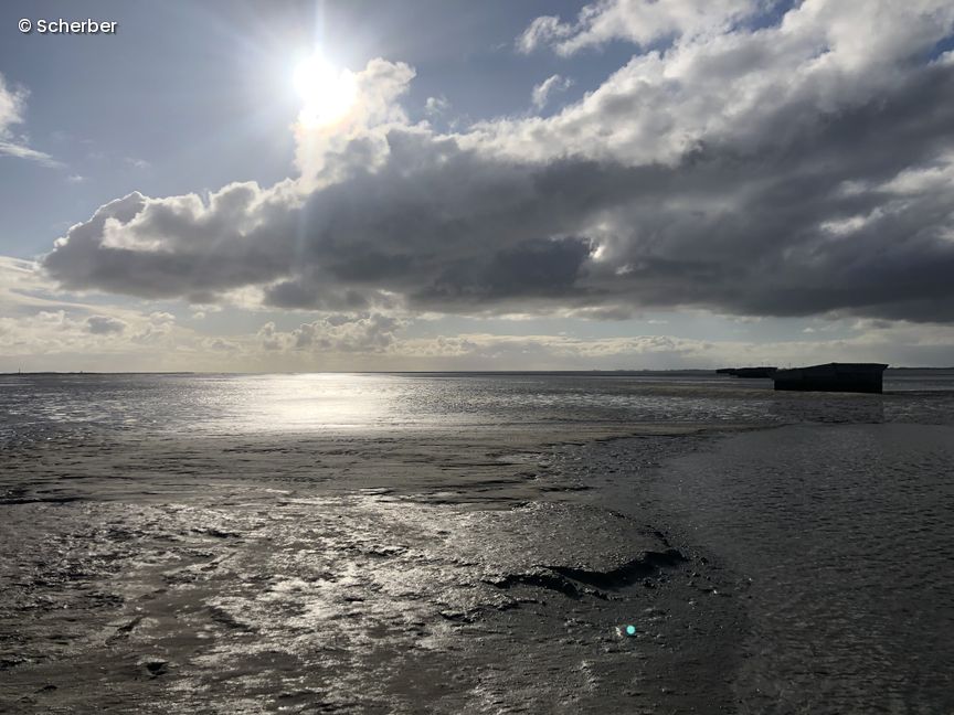 Blick aufs Watt, Sonne blitzt hinter Wolke hervor