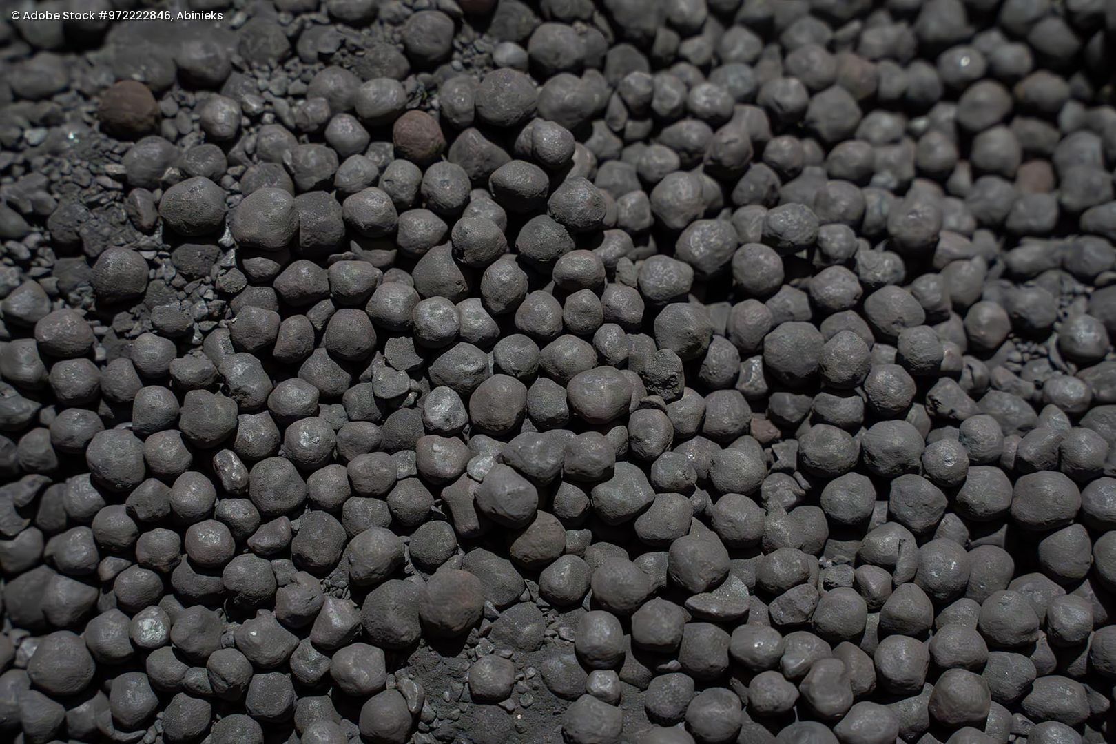 Nahaufnahme von kugelförmigen Eisenerzpellets mit unregelmäßiger Oberfläche