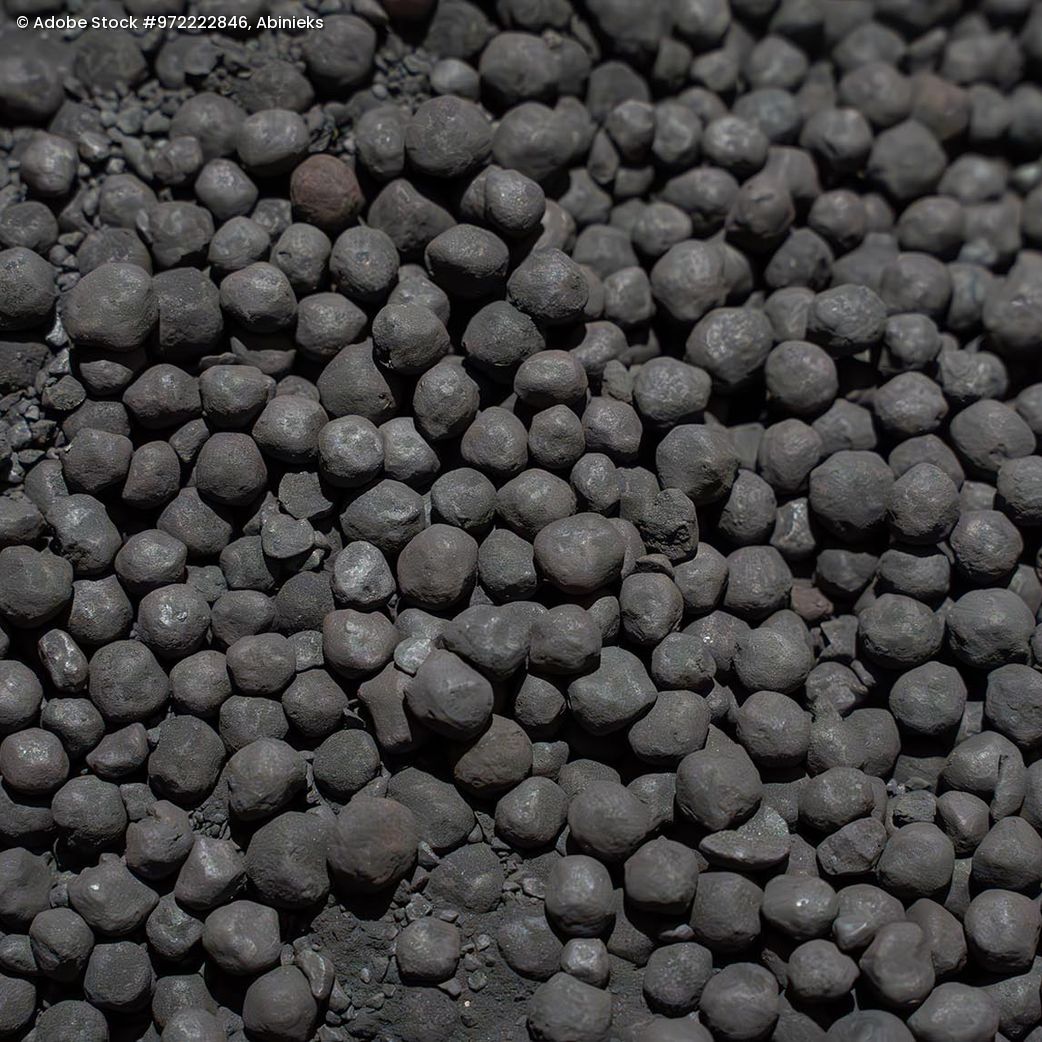 Nahaufnahme von kugelförmigen Eisenerzpellets mit unregelmäßiger Oberfläche