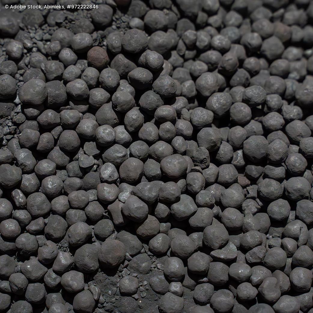 Nahaufnahme von kugelförmigen Eisenerzpellets mit unregelmäßiger Oberfläche