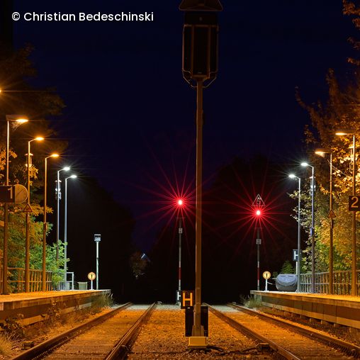 Beleuchteter Bahngleis im Dunkeln